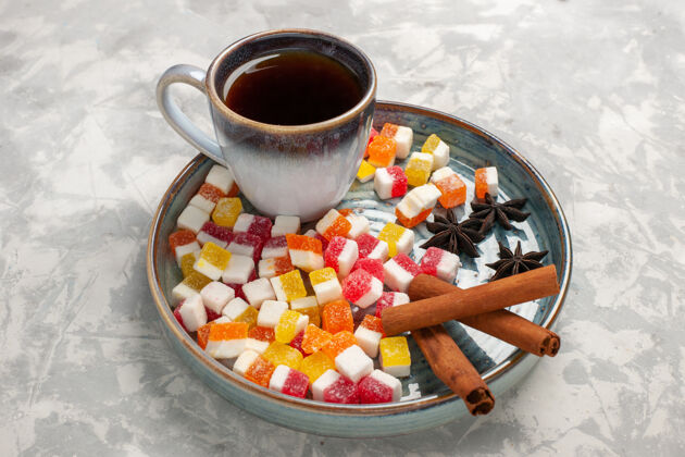 肉桂半顶视图一杯茶与果酱和肉桂淡白色表面果酱食物甜食