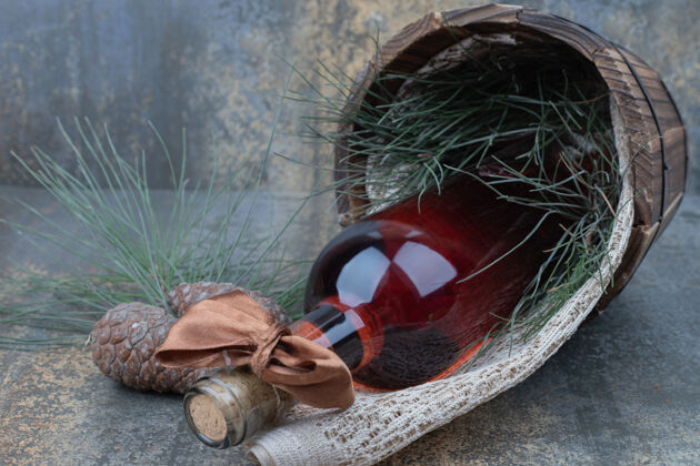 木头两个松果与葡萄酒瓶大理石背景高品质的照片酒节日玻璃