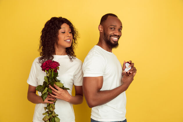 约会决定情人节庆祝 黄色工作室背景上的一对快乐的非洲裔美国夫妇微笑女性男性