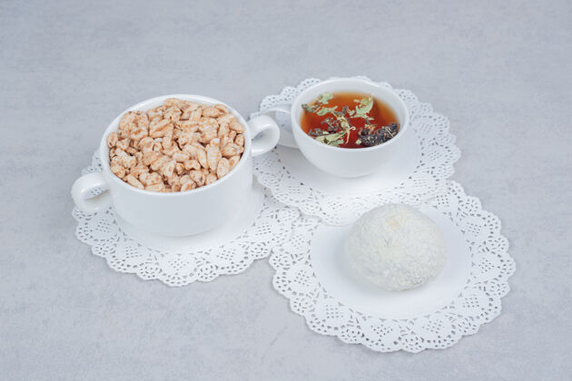 椰子一杯花草茶 椰子饼干和一碗糖果放在白色的桌子上高质量的照片小吃杯子茶