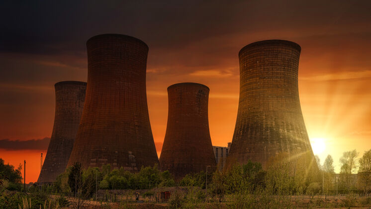电站夕阳下发电厂附近的绿色草地建筑烟囱日出