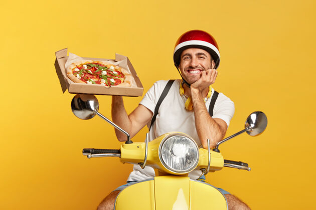 男性面容友好的送货员戴着头盔 手里拿着披萨盒 开着黄色的滑板车朋友包美味