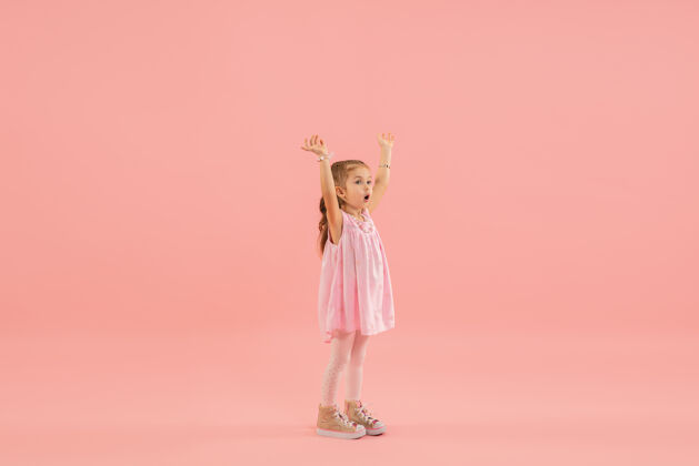 小粉红色墙上穿粉红色衣服的小女孩漂亮童年年轻