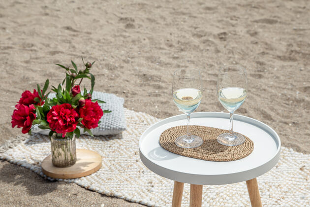 玻璃杯带着鲜花和香槟的野餐度假的概念休息浪漫饮料
