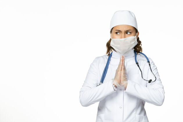 正面正面图年轻女医生由于白色表面有冠状病毒 戴着无菌口罩和手套医疗医生病毒