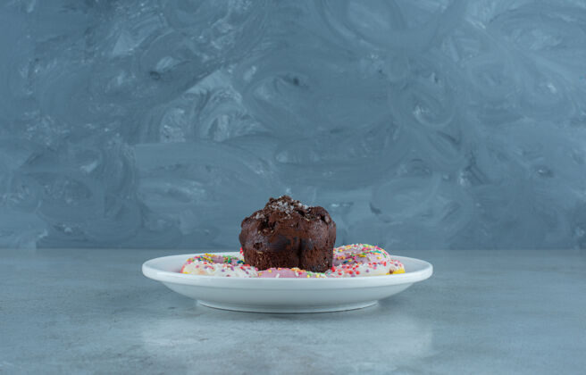 美味甜甜圈和巧克力放在大理石背景的盘子上高质量的照片巧克力烘焙口感