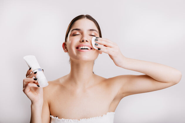 模特快乐女人享受面部spa模特在涂面霜前用海绵清洁面部年轻成人保湿霜