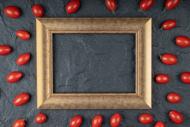 吃在黑色背景上围绕金色框架的樱桃番茄特写照片高质量的照片市场有机樱桃