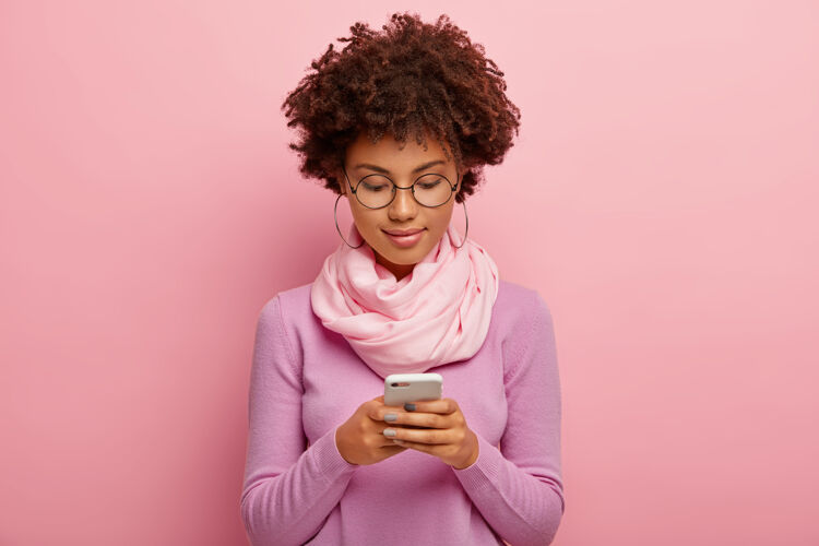 Rosie非洲发型美女横拍 用智能手机设备 集中在显示器上 发短信 连接无线上网脖子上戴紫色套头巾手机电话注意力