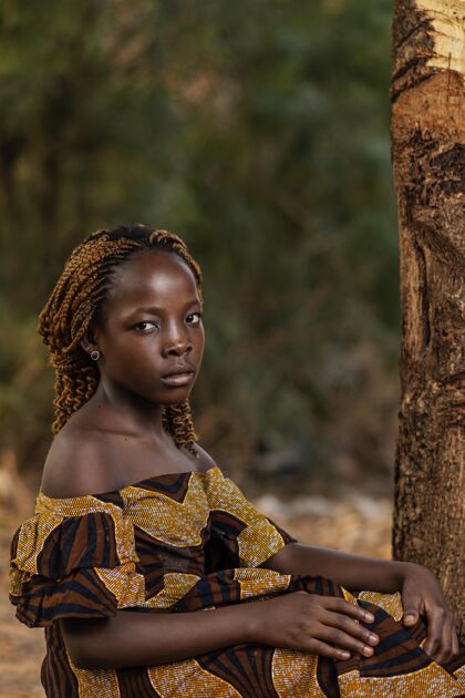 中镜头中镜头非洲女孩在树边摆姿势孩子水平乡村