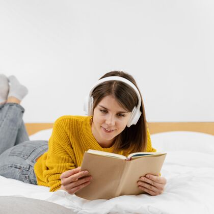广场中镜头笑脸女人在床上看书质量时间乐趣室内