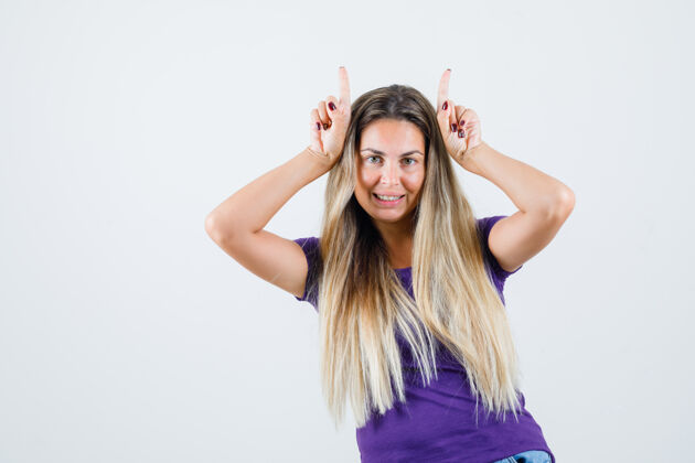 人身穿紫色t恤的年轻女性头上戴着喇叭标志 看上去很滑稽 正面视图角显示成人
