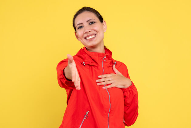情绪正面图黄色背景上穿着红色外套的年轻女性运动员人物肖像