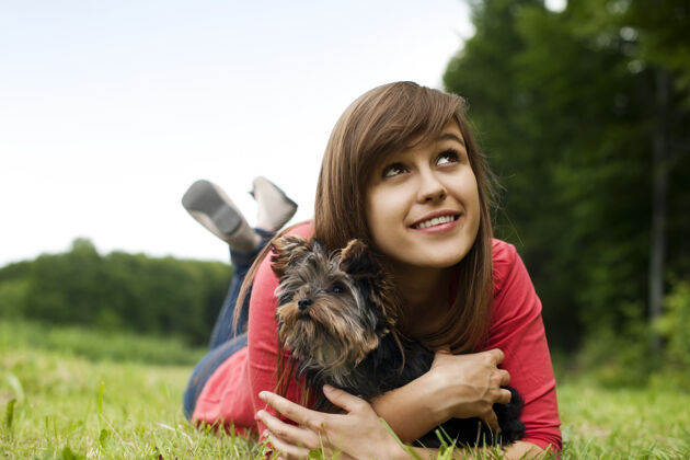 纯种狗抱着约克郡猎犬的年轻女人信任动物宠物友谊