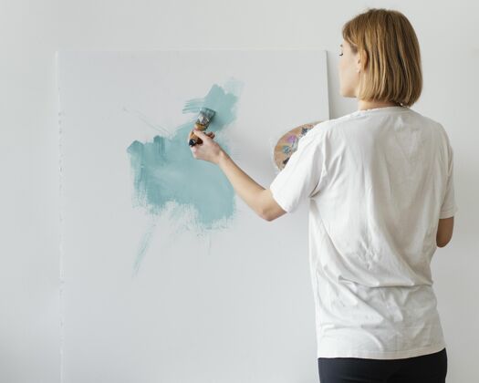 艺术家在画布上用丙烯酸树脂作画的年轻女子绘画室内女人