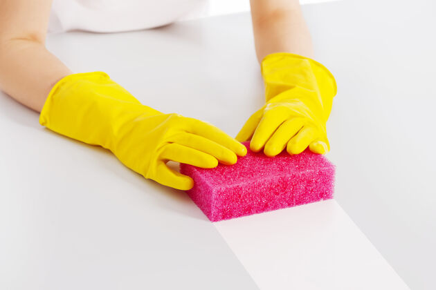 条纹用粉色海绵和防护手套清洁桌子闪亮清洁设备乳胶