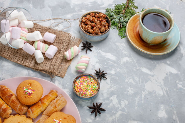 糖在白色的桌子上放上一杯美味的小棉花糖和蛋糕生的晚餐盘子