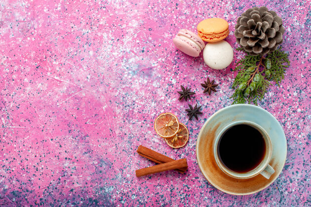 热的俯瞰法国马卡龙美味的小蛋糕与茶粉红色的表面甜食麦卡龙饮料