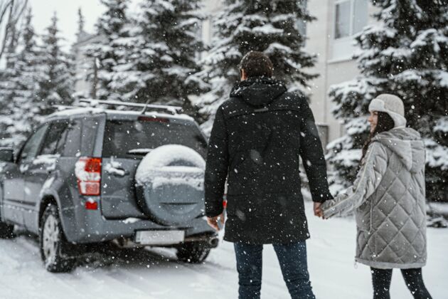汽车一对夫妇享受雪景 而在公路旅行与汽车男性户外冒险