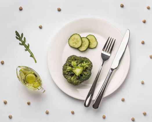 有机把新鲜的西兰花平放在盘子里和餐具一起吃蔬菜烹饪食品