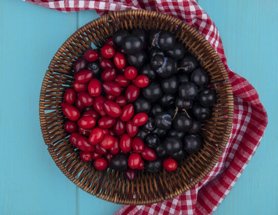 食物顶视图的水果 如山茱萸和树莓在篮子上的格子布蓝色背景树莓蓝色上衣