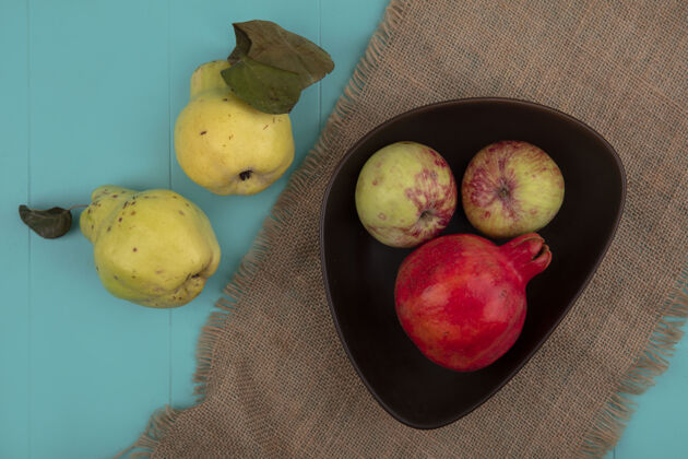 水果新鲜石榴的俯视图 碗上放着苹果 布袋上放着一块蓝色的木瓜木瓜衣服新鲜
