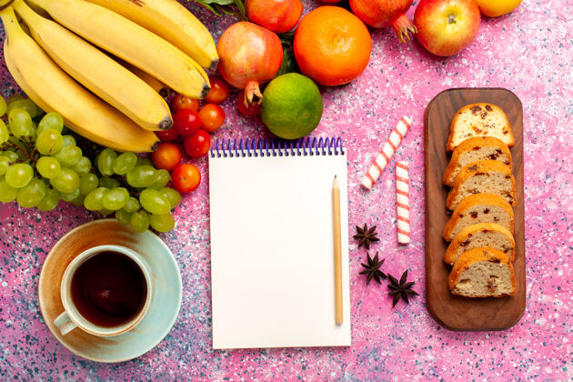 异国情调在粉红色的桌子上可以看到美味的水果和切片蛋糕和茶生的醇香水果
