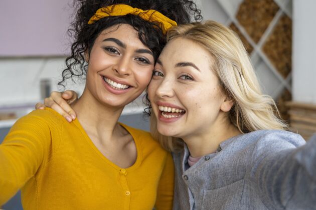 女人两个快乐女人自拍的正面图微笑积极自拍