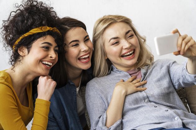 快乐三个快乐的女人微笑着自拍世界欢笑日女人全球