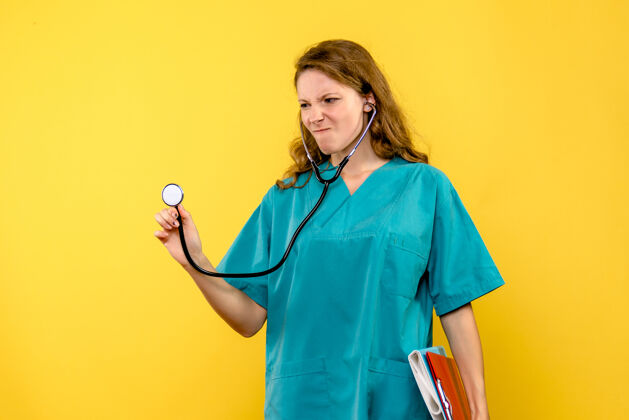 护理前视图黄色空间上的女医生带着文件和听诊器专业听诊器健康