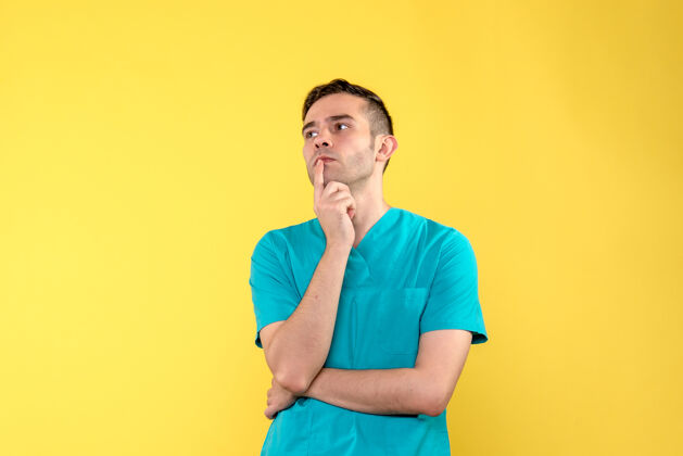人男医生在黄色墙上思考的正视图医学秘书思考