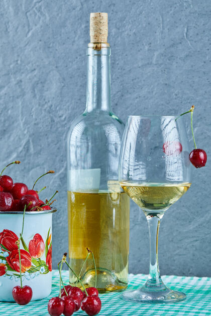 杯子一杯樱桃 一瓶白葡萄酒 蓝色的杯子酒精杯子水果