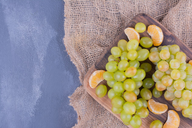 新鲜葡萄串在蓝色表面的木板上美味产品健康