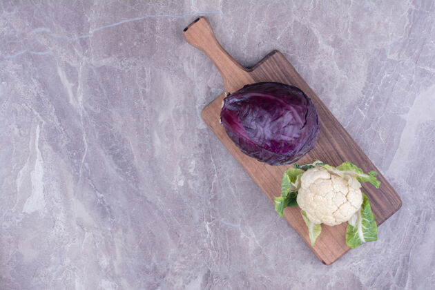 极简把卷心菜和花椰菜放在大理石上的木盘上热带甜味水果