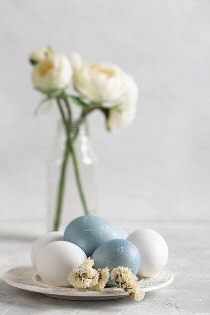盘子复活节彩蛋的正面图 花瓶里有花鸡蛋庆祝花