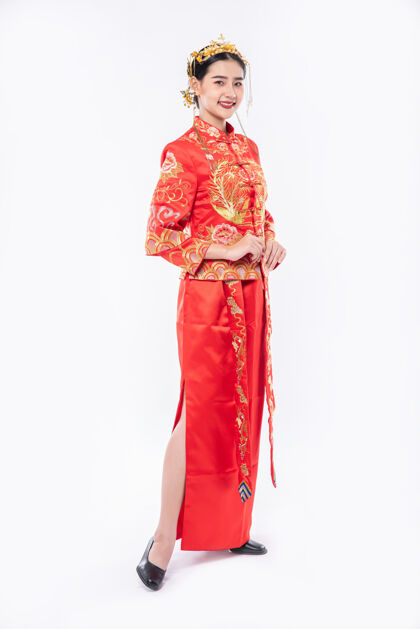 微笑穿旗袍套装的女人微笑着迎接过年购物的旅客文化中国民族女孩