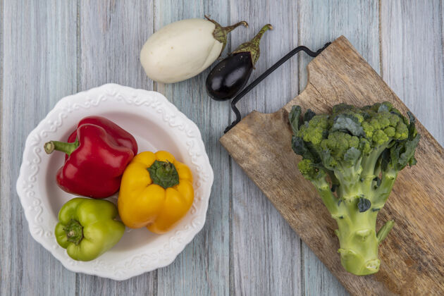 食物顶视图蔬菜辣椒在碗和西兰花在切菜板与茄子在木制背景营养木板碗