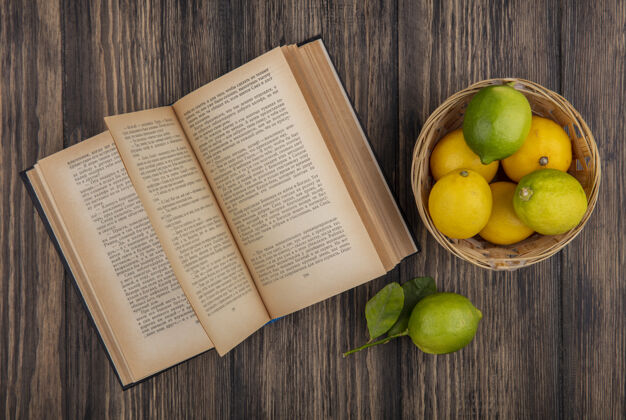 篮子在木制背景上打开书的篮子里 可以俯瞰柠檬和酸橙食物柠檬景观