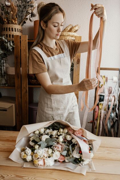 美丽做漂亮插花的女人花店商店工作