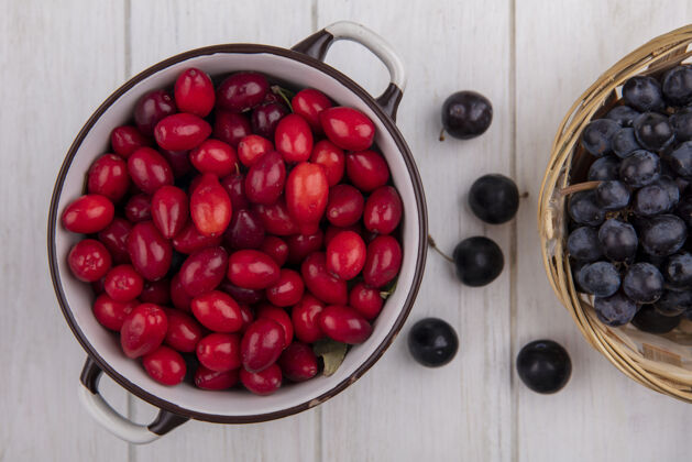 罐子顶视图山茱萸与樱桃和黑葡萄在一个白色背景的篮子锅樱桃视野新鲜