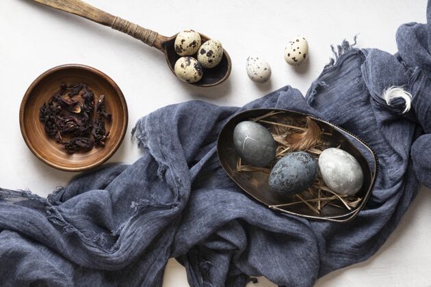 盘子用木勺子和纺织品把复活节彩蛋平放节日复活星期天复活节