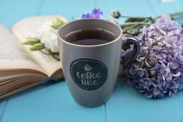风景一杯茶的顶视图 蓝色木质背景上有一朵美丽的丁香花杯子饮料奇迹
