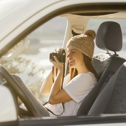 旅行拿着照相机的中镜头女人旅行者公路旅行旅游