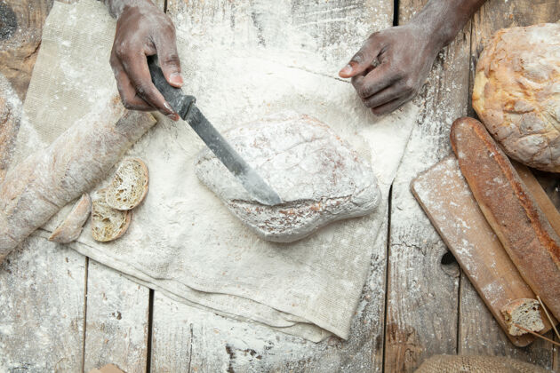 工艺非洲裔美国人在木桌上烹调新鲜的谷类食品 面包 麸皮美味的食物 营养 工艺产品无麸质食品 健康的生活方式 有机和安全的制造手工制作面包手工切片