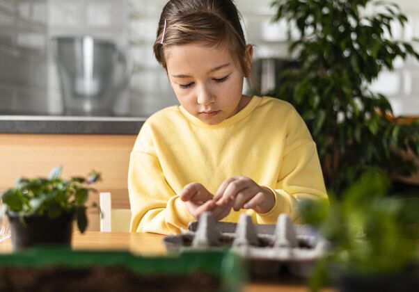 蔬菜小女孩在家里播种的正面图庭院植物园艺