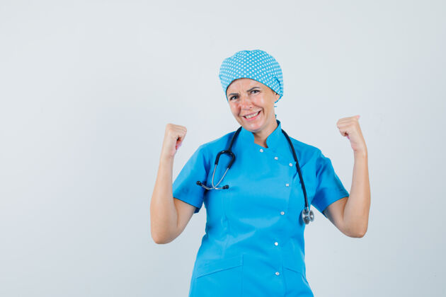 制服女医生身着蓝色制服 展现获奖者的姿态 看上去很幸运 正视图治疗护士年轻人
