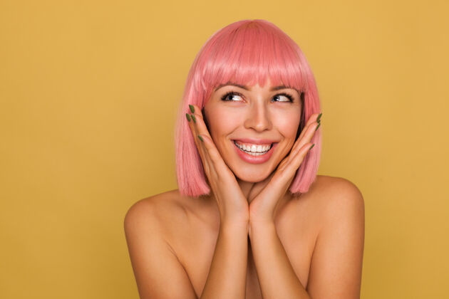 动画一位年轻可爱的粉红头发女士的肖像 自然的妆容展现出她完美洁白的牙齿 微笑着 下巴靠在举起的手上 在芥末墙上摆姿势女人年轻提高