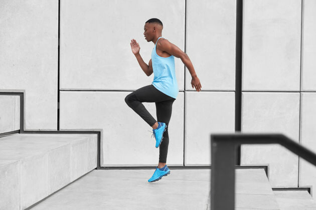 男子穿运动服的男运动员的水平视图 有氧运动上楼准备长距离慢跑 做台阶或跳高穿t恤 紧身裤 运动鞋的非裔美国人休闲活动肌肉