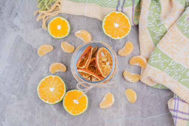 水果把桔子片放在石头表面的玻璃罐里橙子干的柠檬