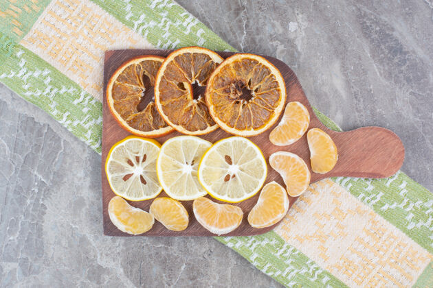 柠檬用桌布把柑橘片放在木板上新鲜切片水果
